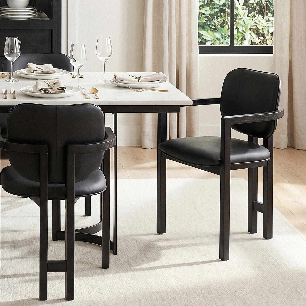 Carlisle Curved Back Black Leather Tripod Frame Dining Armchair by Mercana at Eve Furniture